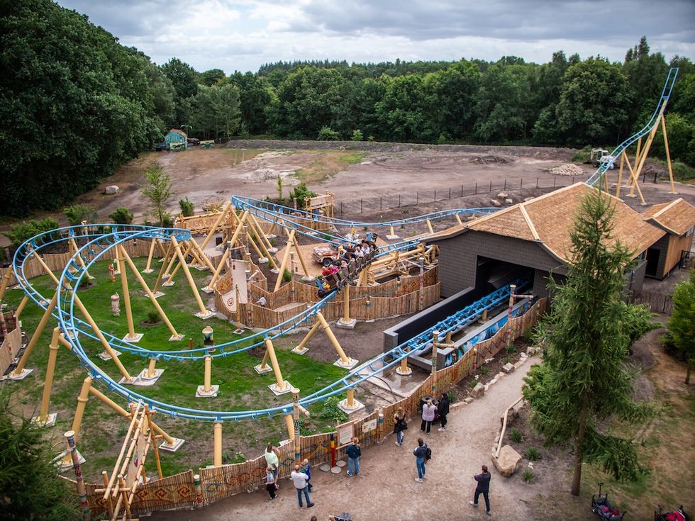 Maui's Peak outdoor roller coaster at Tier- und Freizeitpark Th\u00fcle with a blue track winding through a wooded area.
