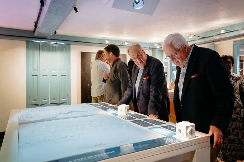 Men examining an illuminated table display at the Edward W. Kane & Martha J. Wallace Center for Black History.