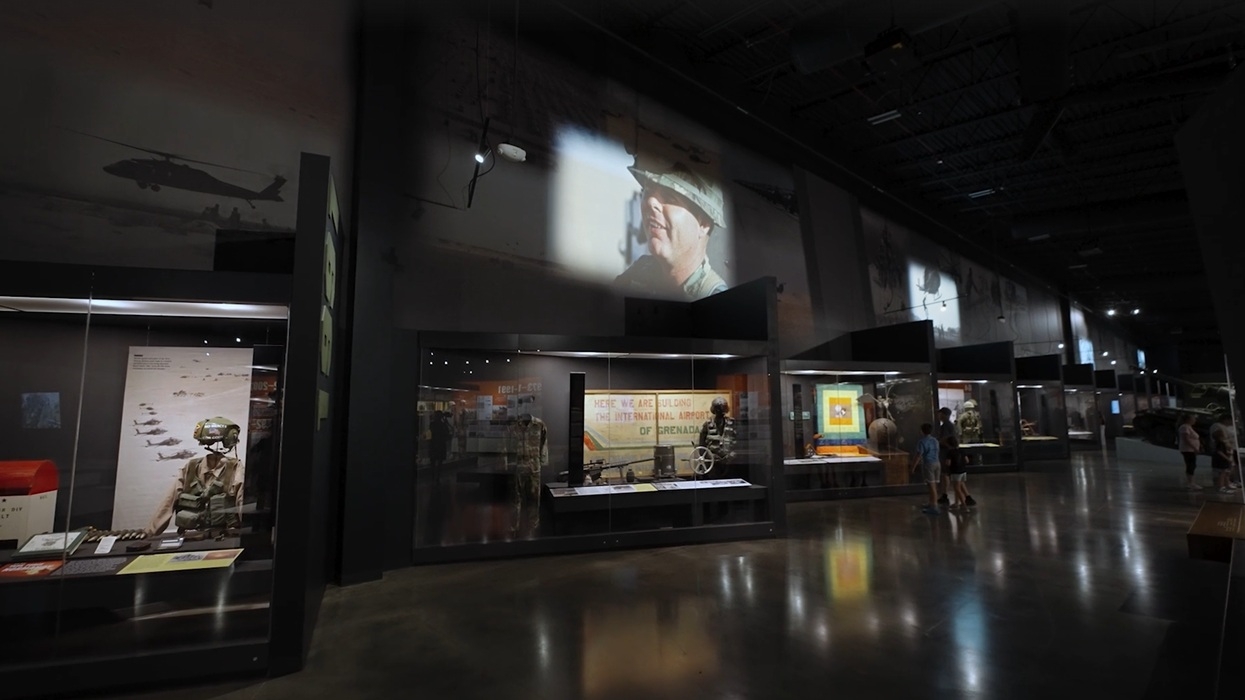 Military museum exhibit with uniforms and aircraft shadows on the wall at the Tennessee Wings of Liberty Museum
