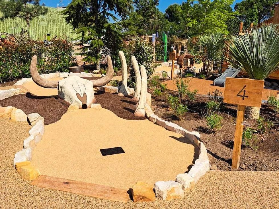 Mini-golf hole with large bull skull, surrounded by plants and sign marked "4".