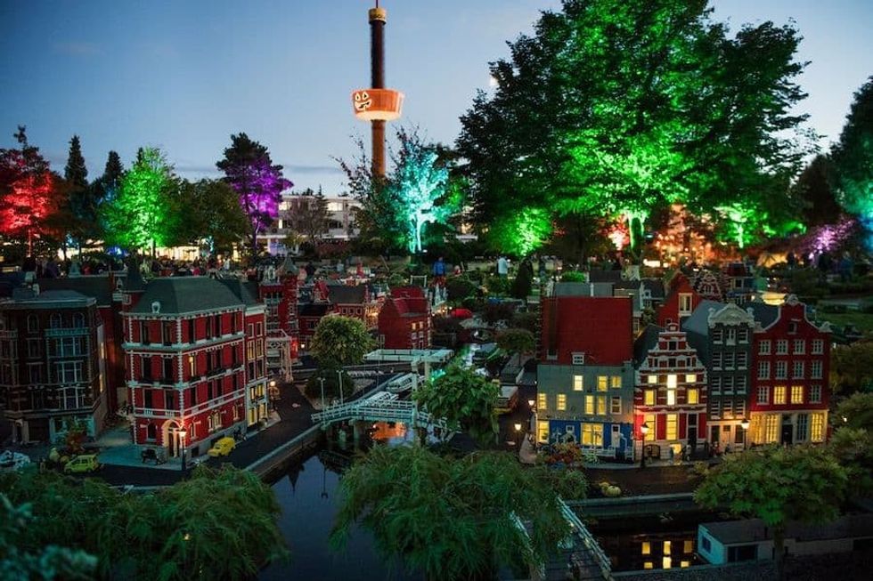 Miniature cityscape with colorful lights and vibrant trees at night, Legoland Billund