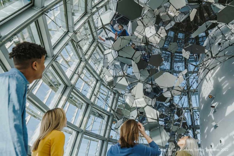 mirador torre glories blooloop innovation awards 2022 people standing in the glass observation deck looking at a sculpture of clouds