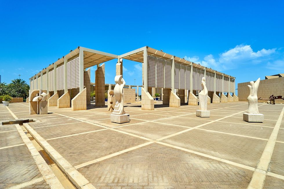 Modern architectural structure at Bahrain National Museum, with sculptures in a spacious, sunlit courtyard.