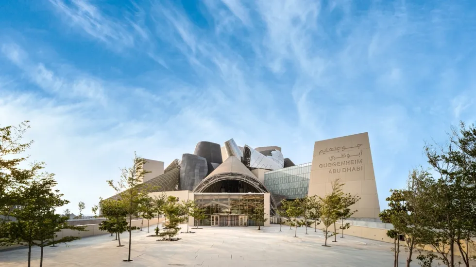 Modern architecture of the Guggenheim Abu Dhabi under a clear blue sky.