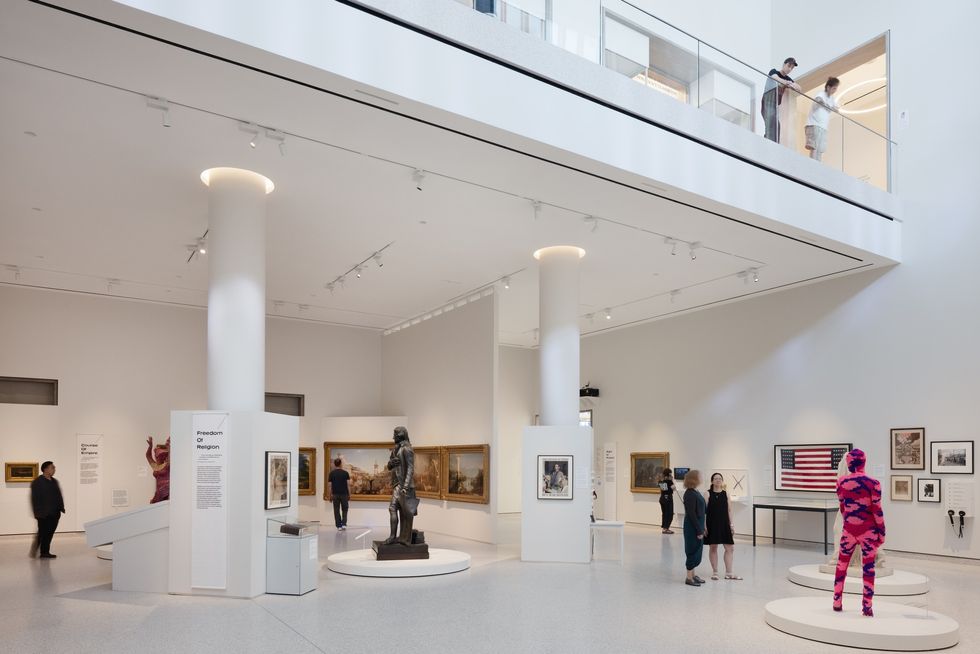 Modern art gallery interior at the Tang Wing with sculptures, paintings, and people observing exhibits.