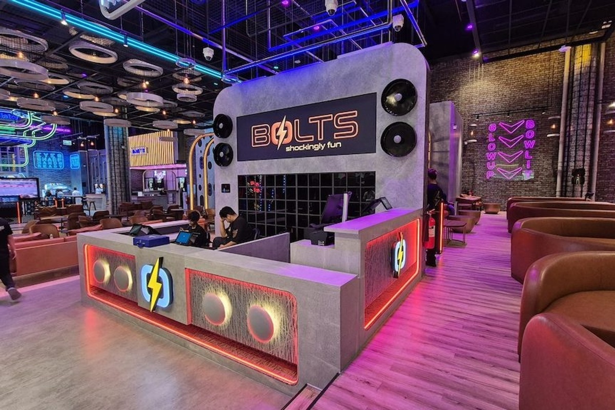 Modern bowling alley at BOLTS with neon lights and sleek seating area.