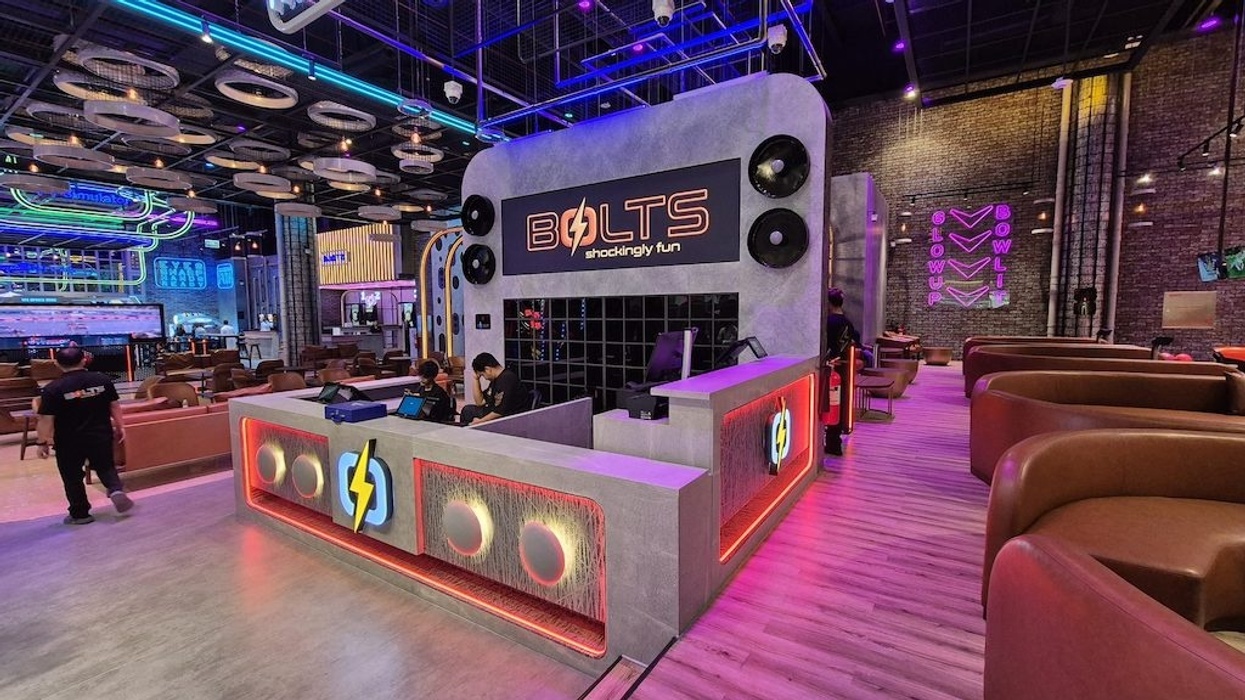 Modern bowling alley at BOLTS with neon lights and sleek seating area.