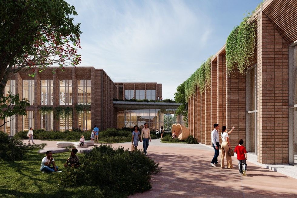 Modern brick building with greenery, people walking and relaxing outside under a clear sky.