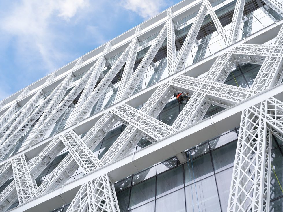 Modern building called Powerhouse Parramatta with crisscross white lattice facade against a blue sky.