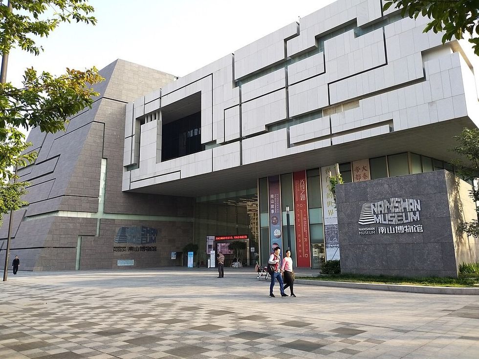 Modern building of Nanshan Museum with people walking in front.