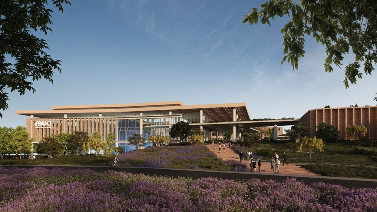 Modern building with a large glass facade, surrounded by greenery and a lavender field.