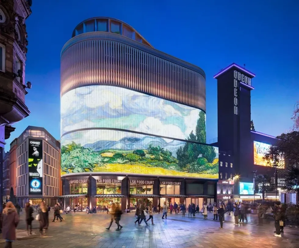 Modern building with large digital artwork and people in a lively evening scene.