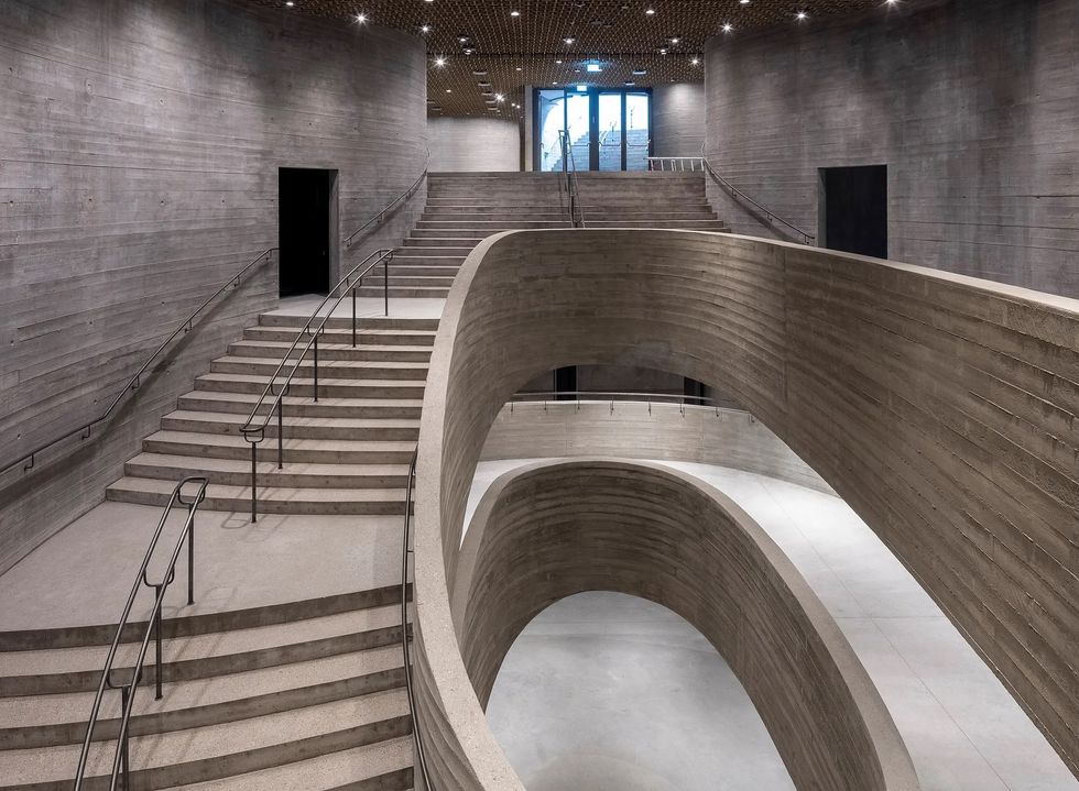 Modern concrete interior with sweeping curved staircases and minimal design at Denmark Natural History Museum