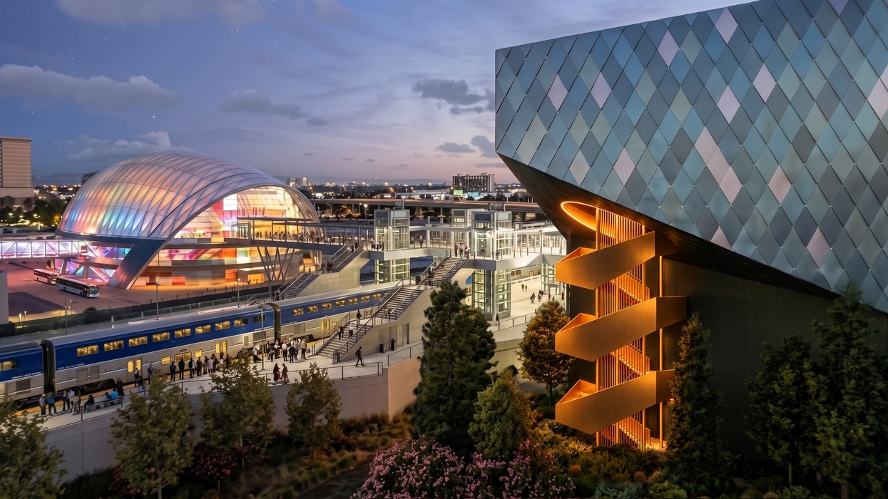 Modern district at dusk, with a blue train, glowing architecture, and geometric glass buildings.