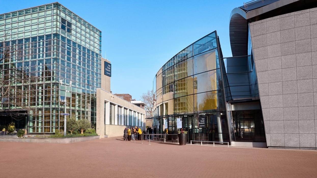 Modern glass and stone building called the Van Gogh Museum under a clear blue sky.