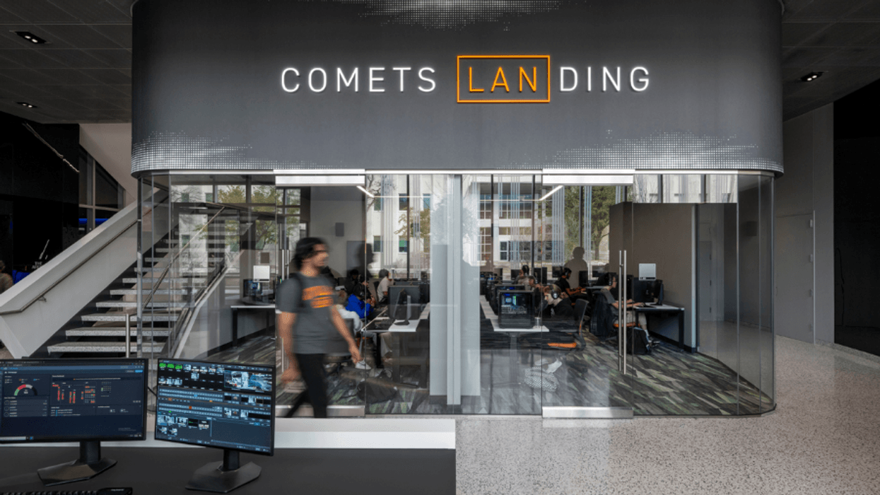 Modern office space with glass walls, labeled "Comets Landing," features computer workstations.