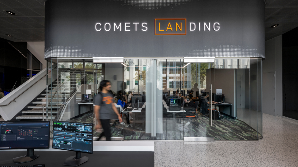 Modern office space with glass walls, labeled "Comets Landing," features computer workstations.