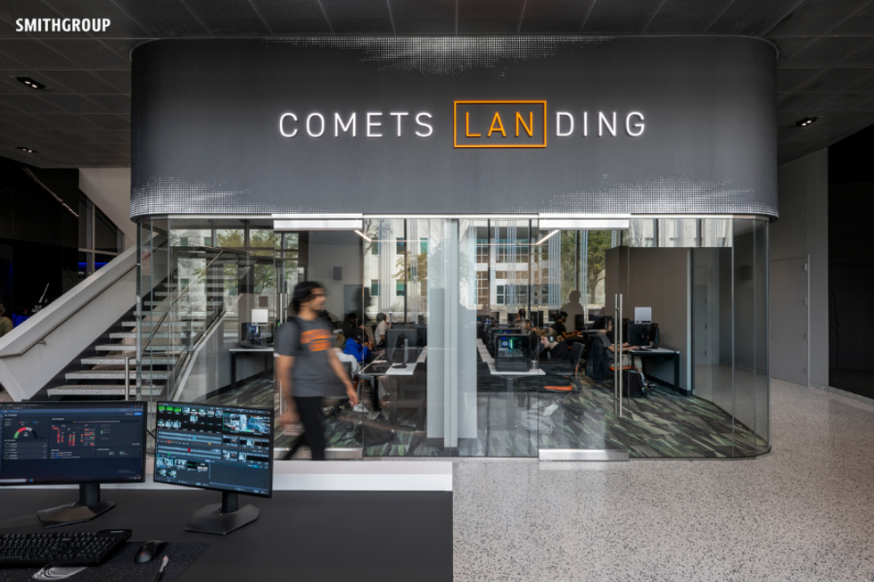 Modern office space with glass walls, labeled "Comets Landing," features computer workstations.