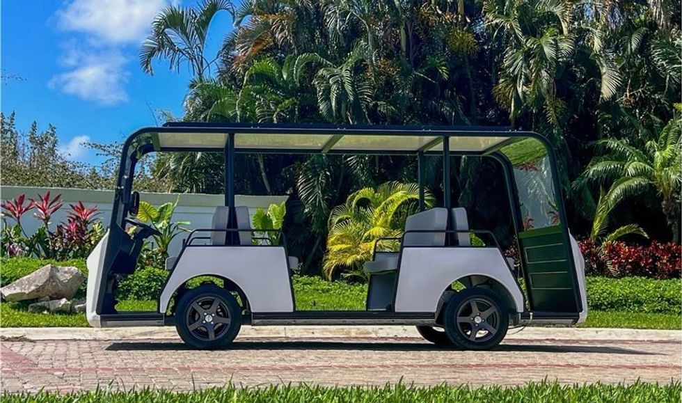 Modern open-air shuttle parked, surrounded by lush tropical greenery.