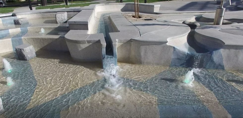 Modern park water feature with cascading streams and small fountains.