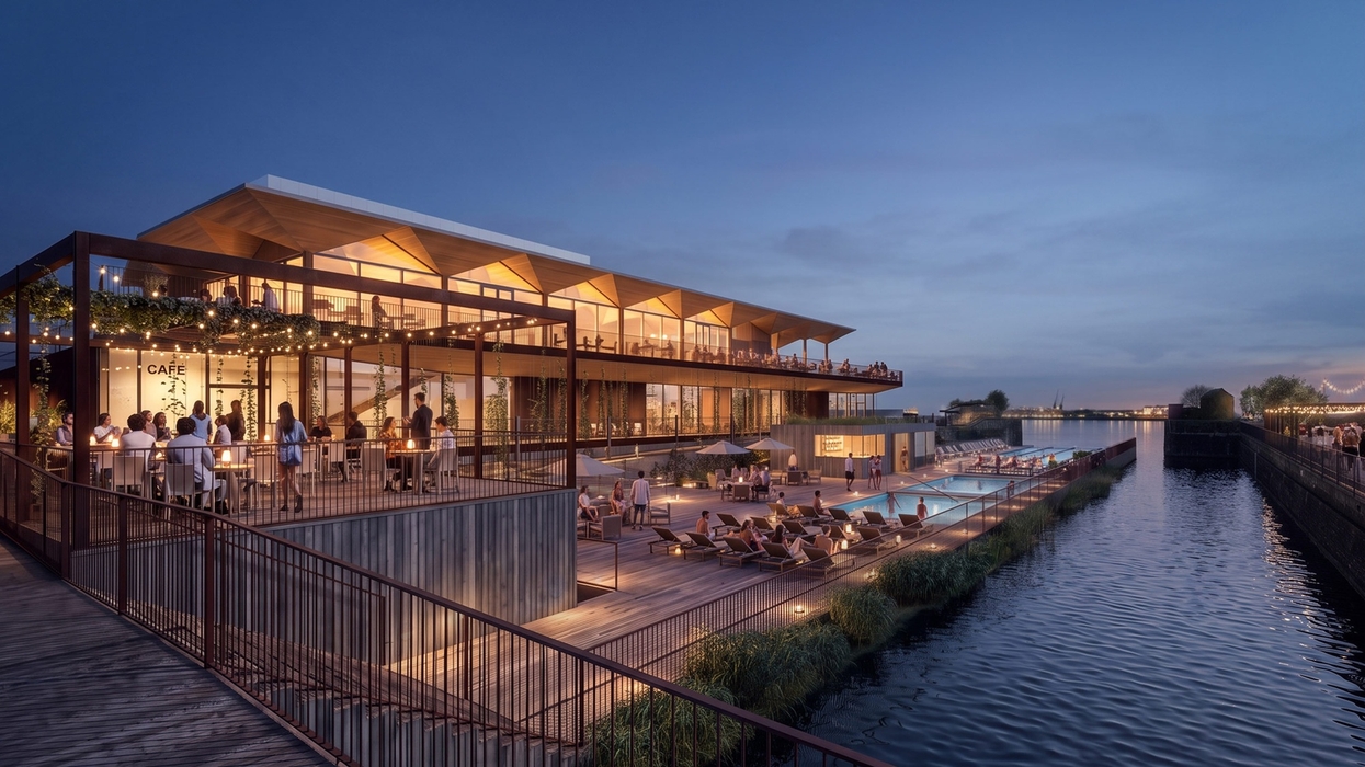 Modern riverside cafe with pool area at dusk, featuring outdoor seating and lights.