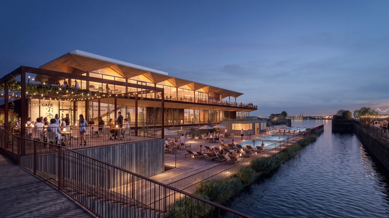 Modern riverside cafe with pool area at dusk, featuring outdoor seating and lights.