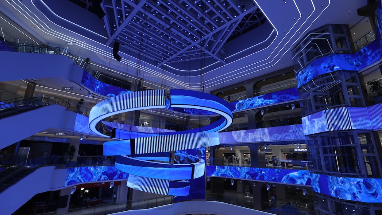 Modern shopping mall interior with blue LED spiral ceiling lights.