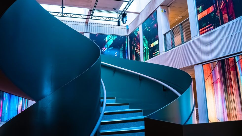 Modern spiral staircase with colorful digital displays on walls in a building interior at Culture House in Sunderland