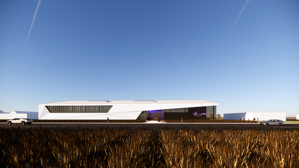 Modern white building with angular design against clear blue sky.