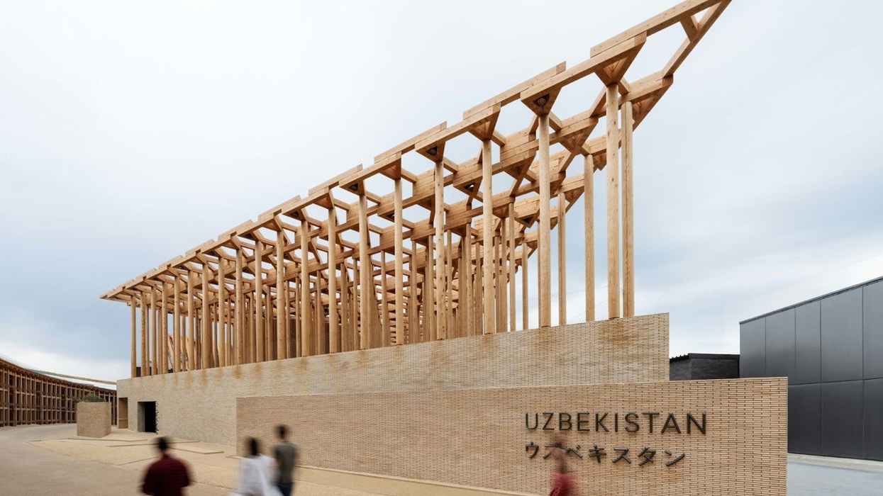 Modern wooden structure of Uzbekistan Pavilion with people walking in front.