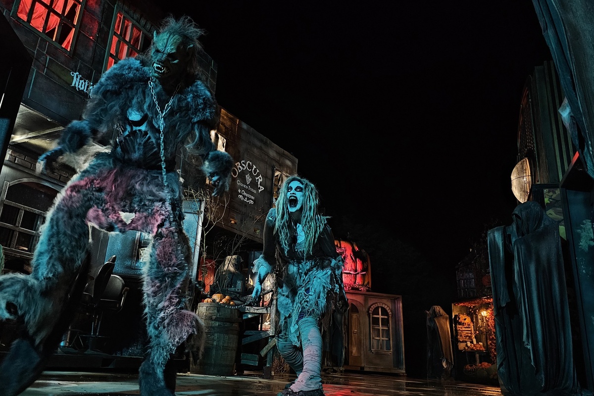 Monsters in a haunted street scene with eerie lighting and spooky decor.