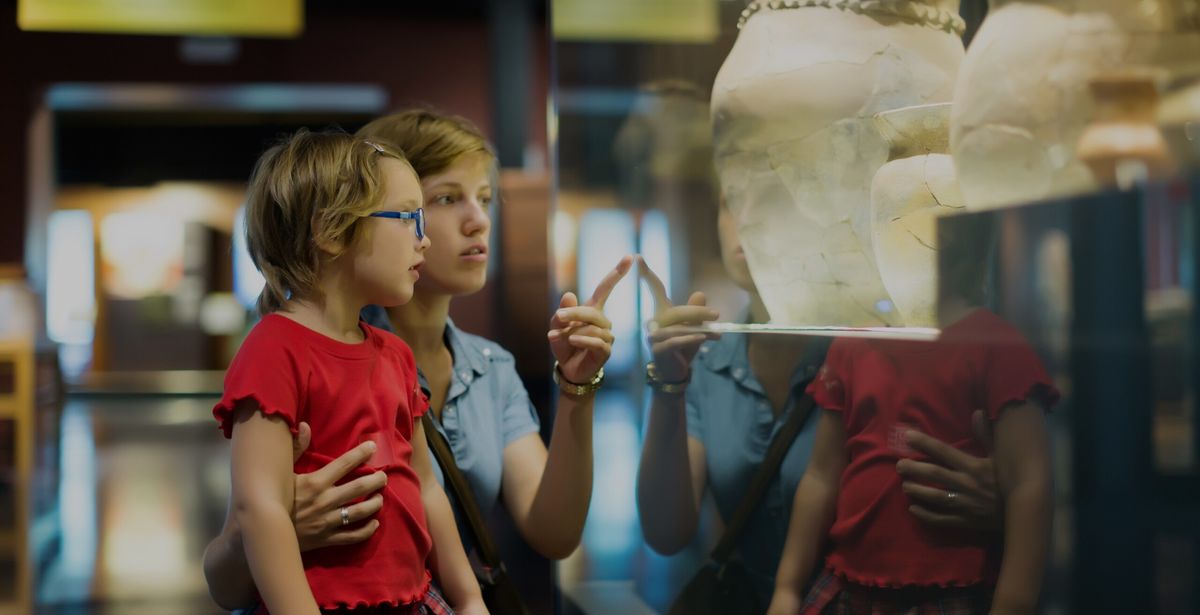 mother and child looking ancient amphores in museum