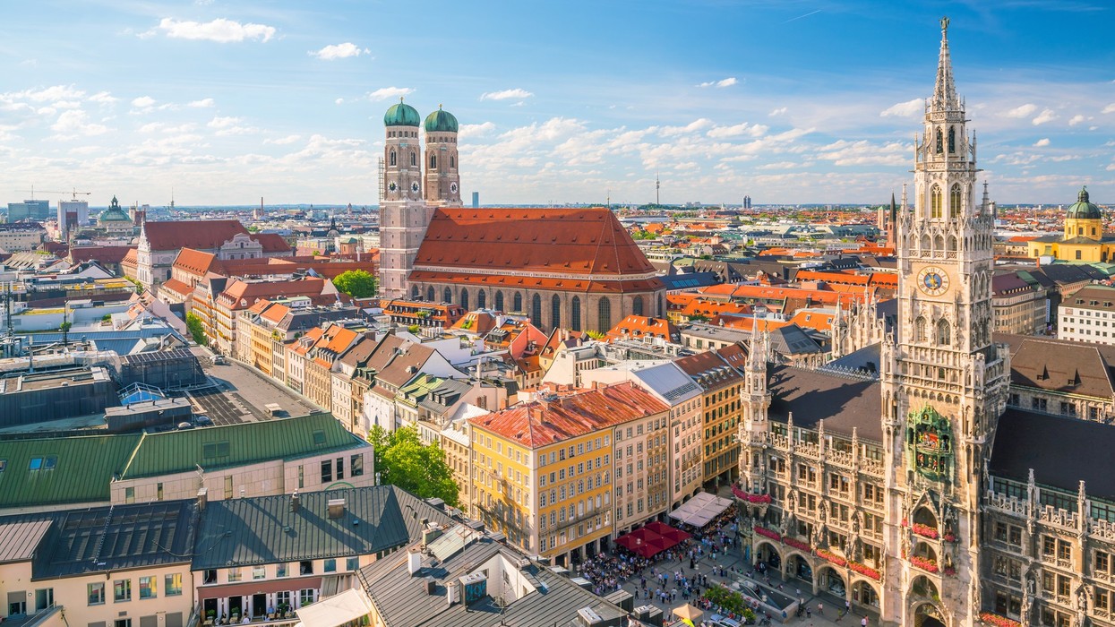 Munich skyline with Frauenkirche and Neues Rathaus under a blue sky.
