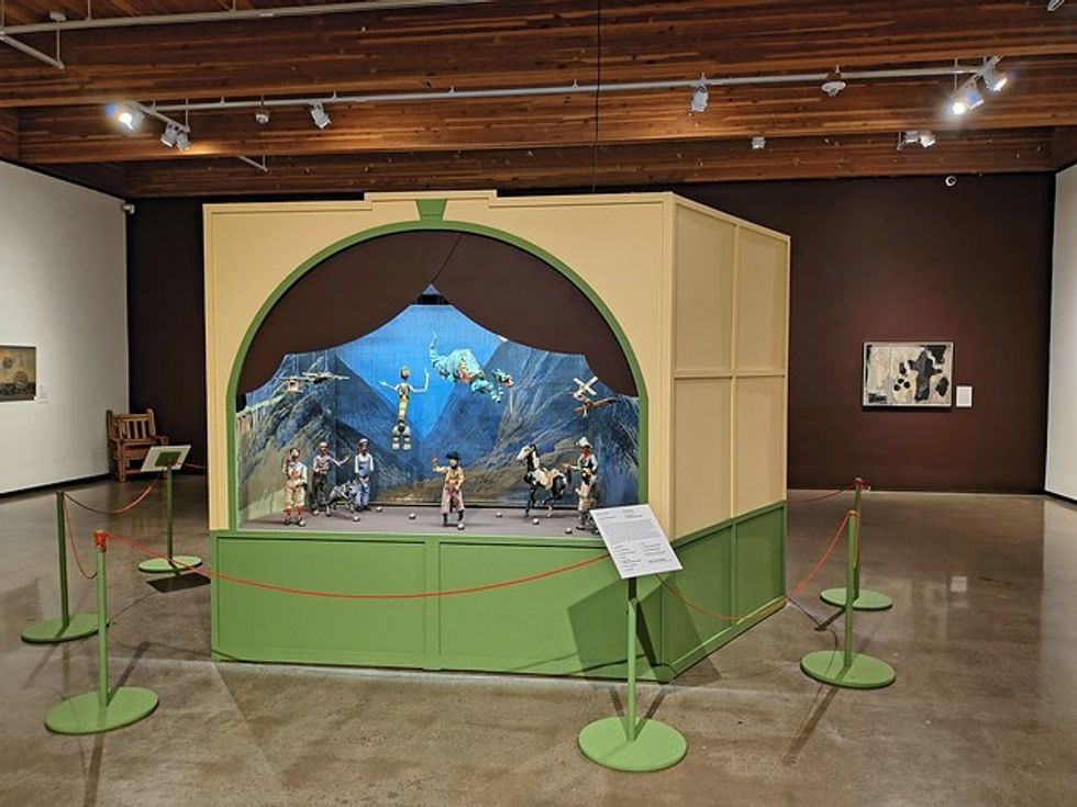 Museum diorama featuring marionettes in a scenic landscape display.