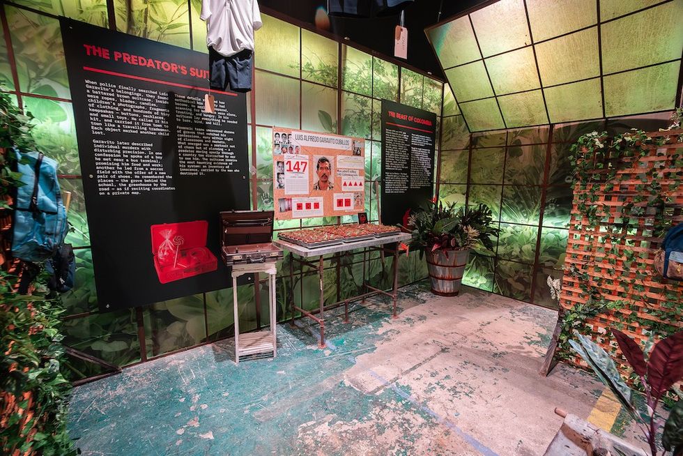 Museum exhibit on serial killers with informative panels and jungle-themed decor.