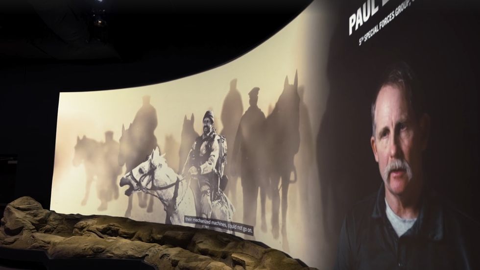 Museum exhibit with horse riders and a portrait of a man with a mustache at the Tennessee Wings of Liberty Museum