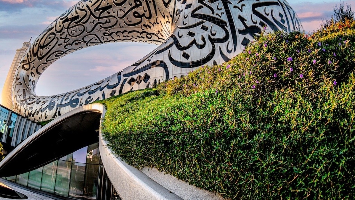 Museum of the Future in Dubai, a futuristic building with Arabic script and greenery under a colourful sky.