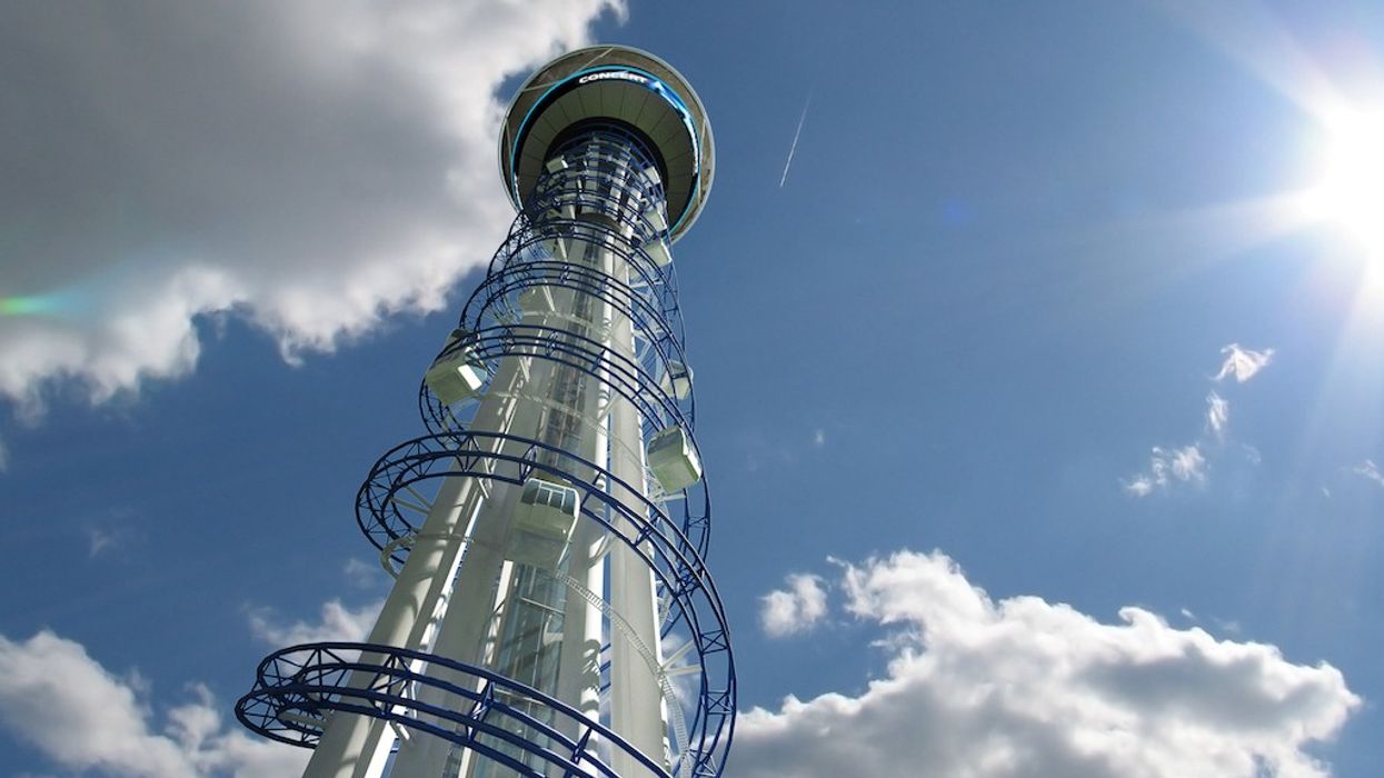 MV Rides SkySpire tower against a blue sky with clouds and bright sun.