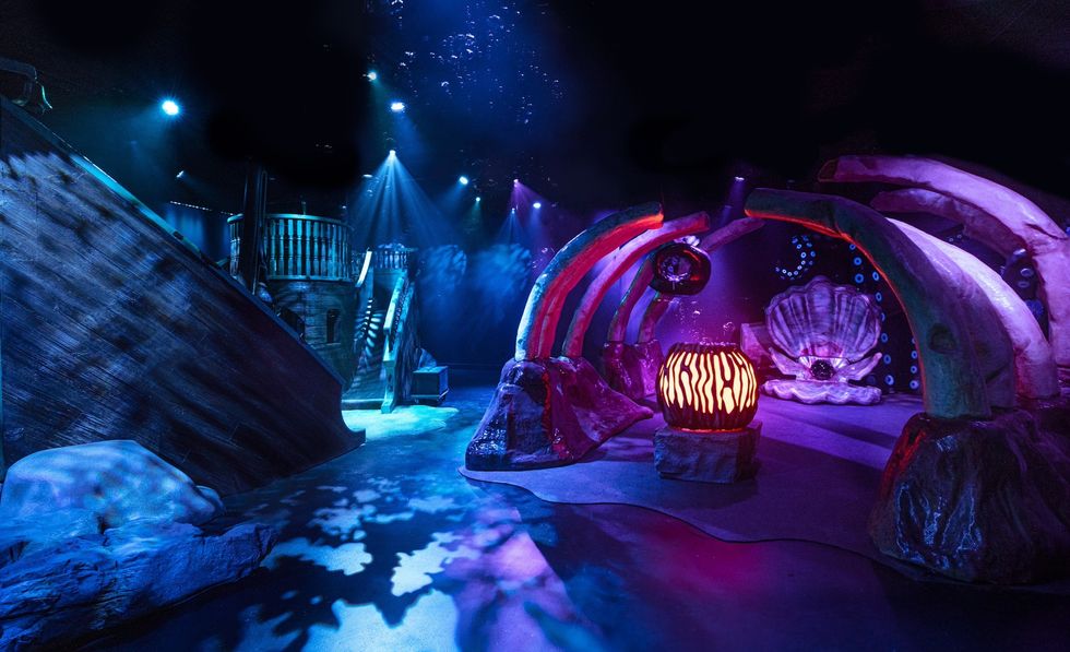Mystical underwater-themed room with blue and purple lights and coral-like structures at Camp store