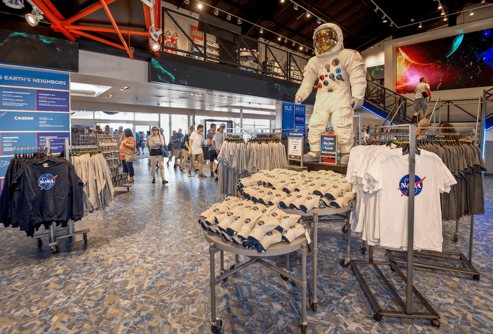 NASA gift shop with astronaut suit display and clothing for sale.