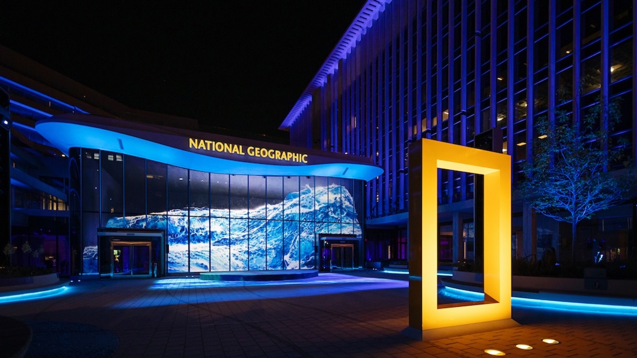 National Geographic building at night with blue lighting and prominent yellow frame.