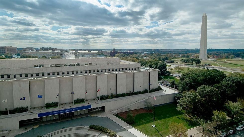 National Museum of American History and Washington Monument under a cloudy sky.