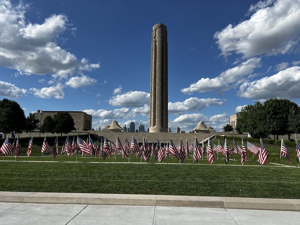 National WWI Museum and Memorial surrounded by American flags under a blue sky with clouds.