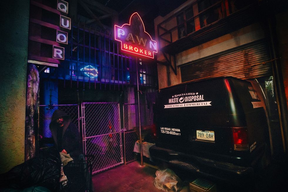Neon-lit pawn shop alley with a parked waste disposal van.