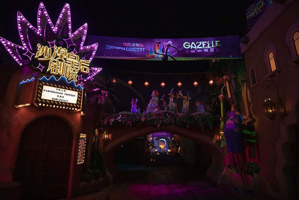Neon-lit theater entrance for Gazelle's Zootopia Concert, with colorful animal figures.