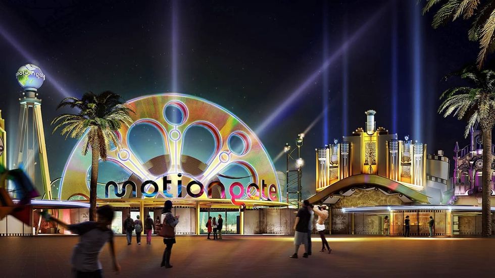 Night view of Motiongate theme park entrance, colorful lights, and palm trees.
