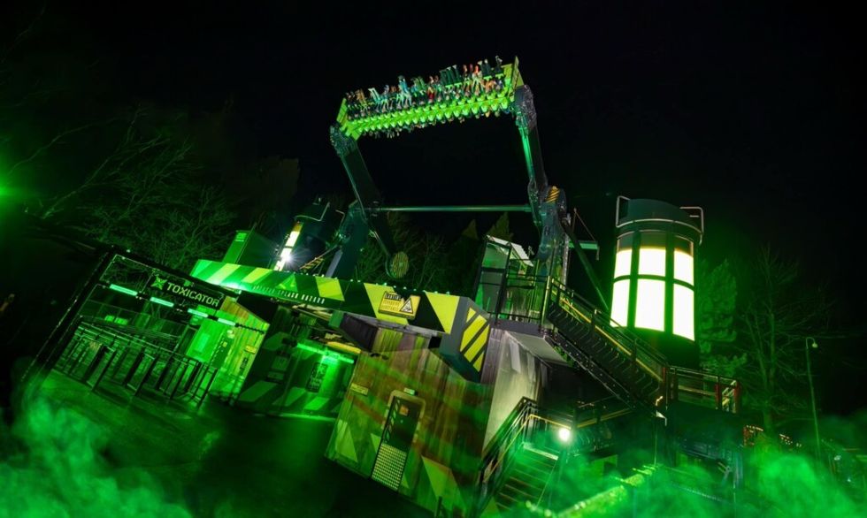 Nighttime ride on Alton Towers' Toxicator, glowing green in eerie fog.