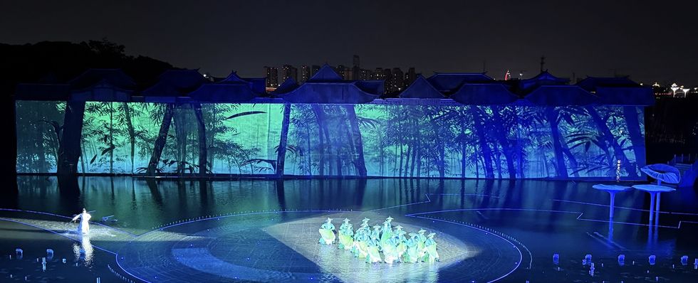 Nighttime water performance, titled The Wonders of Lu You, with illuminated dancers and forest backdrop projections.