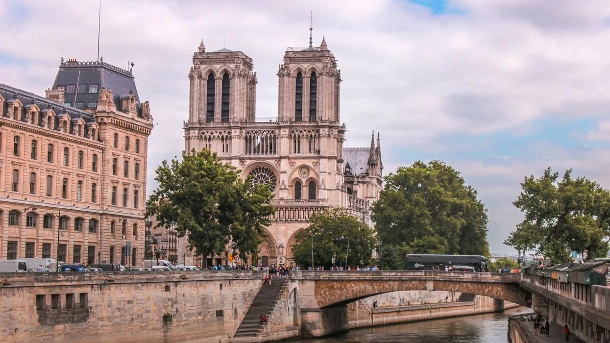 Notre-Dame Cathedral with a bridge over the Seine River in Paris.