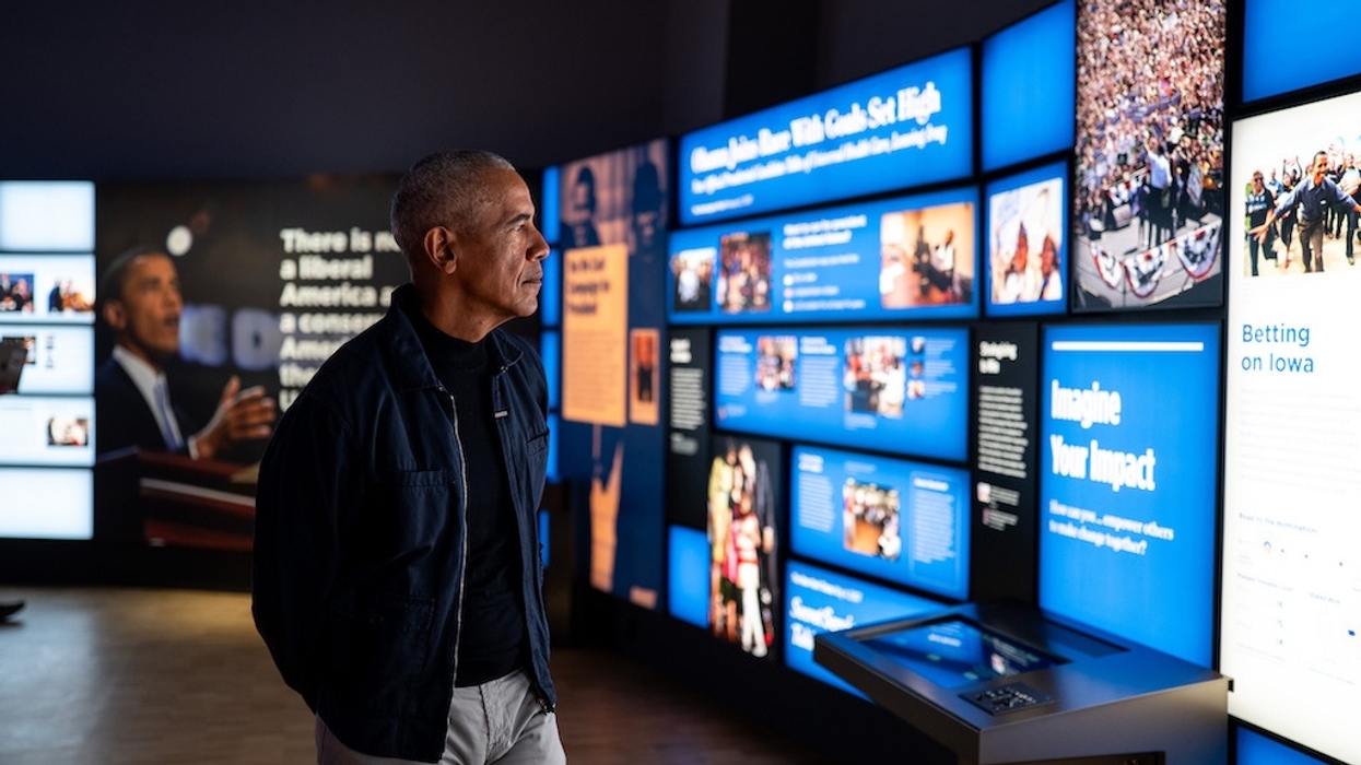 Obama observing a digital display wall in a modern museum exhibit at Obama Presidential Center Museum